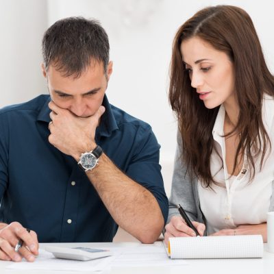 Portrait Of A Worried Couple Calculating Financial Budget